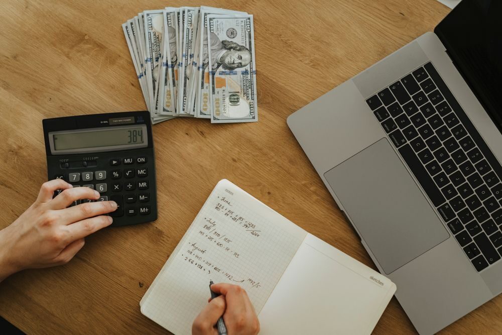 Budget planning with cash, a calculator and a notebook