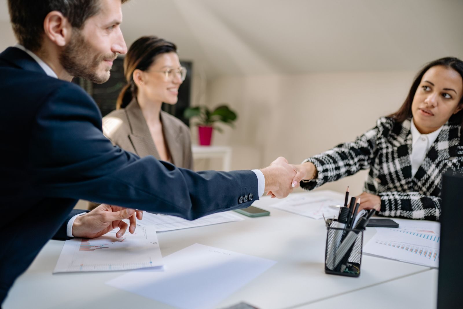 Financial advisor shaking hands with clients at Money Wealth Track