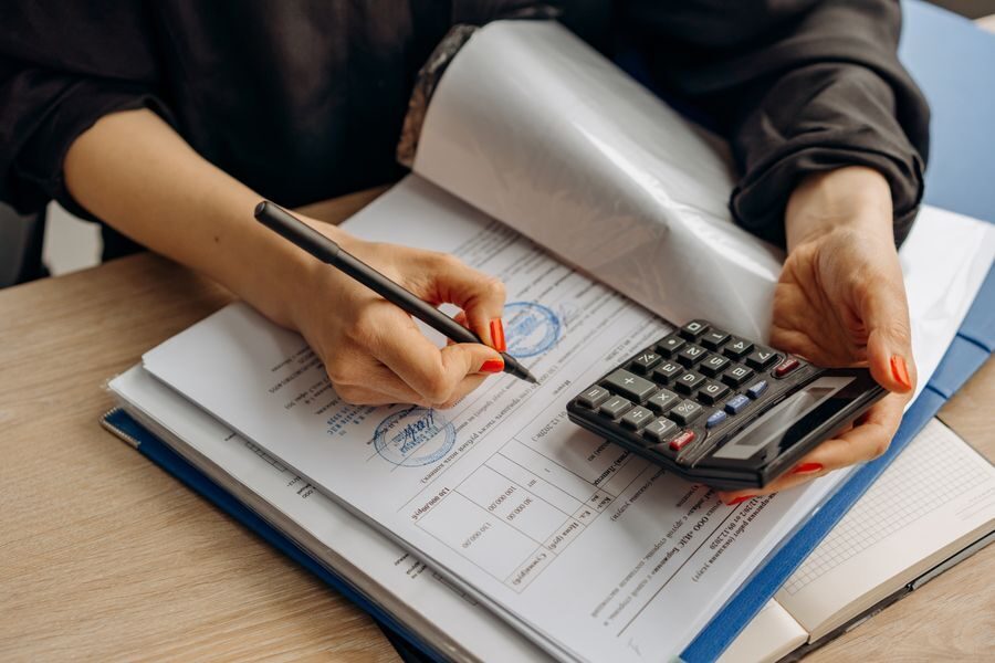 Accountant working through tax paperwork with a calculator